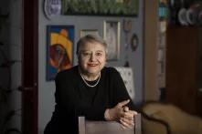 Cânân Arın posa recargando sus manos sobre una silla